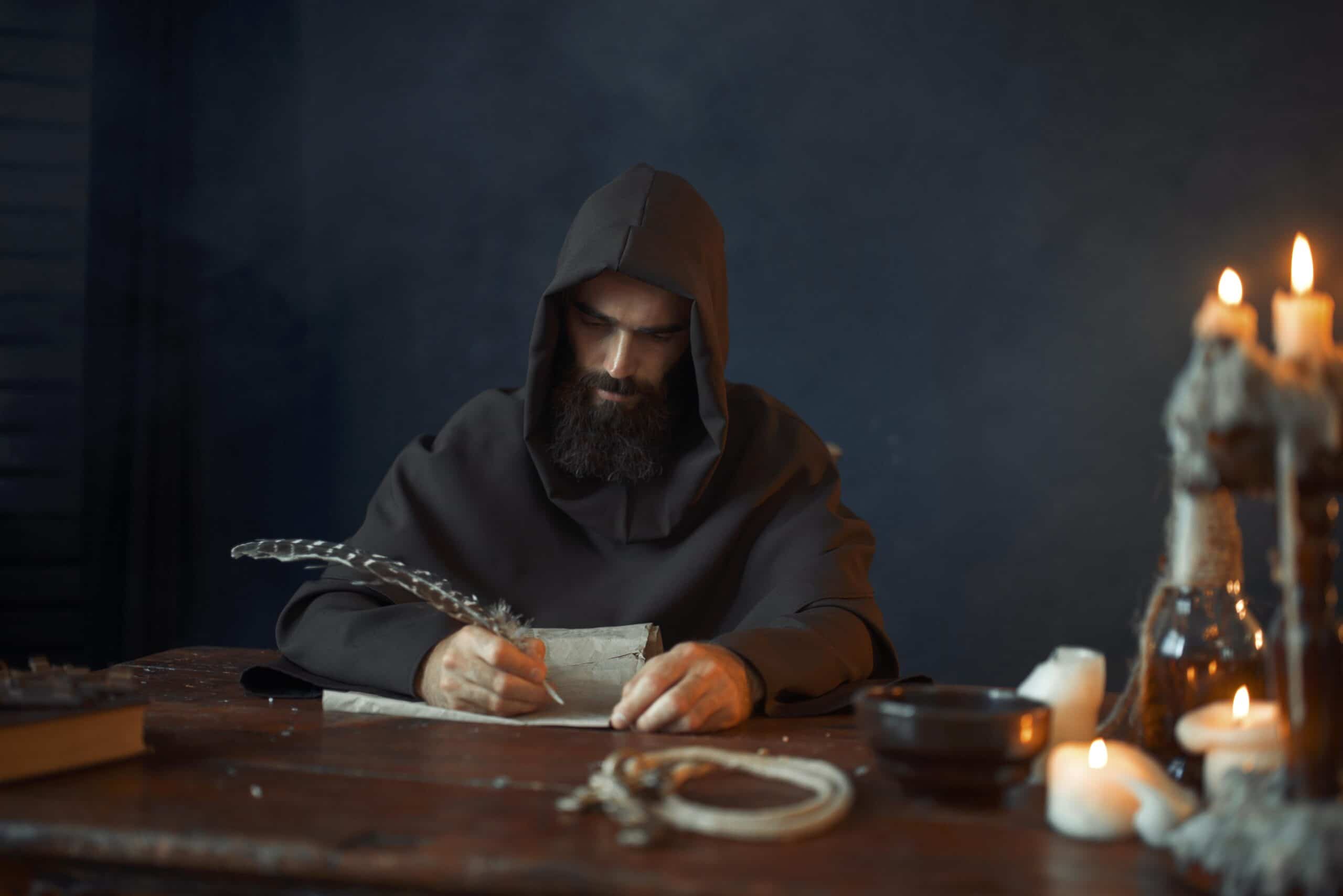 medieval monk sitting at table and write, top view